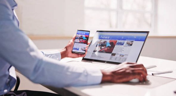 Watching News On Screen. Reading Newspaper Website On Laptop